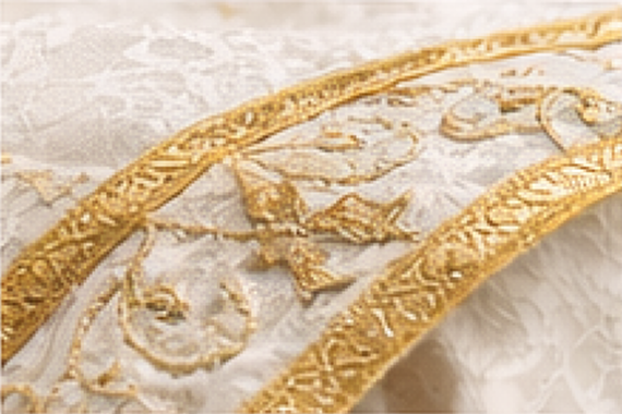 Bordado sacro dourado numa casula litúrgica branca